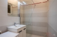 Koupelna s modern�m designem, sprchov�m koutem a sv�tl�mi dla�dicemi, nab�z� elegantn� �ist� linie a praktick� �lo�n� prostory.