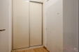 P�eds�� s parketovou podlahou, b�l� st�ny, vestav�n� sk��n�, modern� styl.