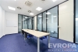 Modern� konferen�n� m�stnost s prosklen�mi st�nami, modr�m kobercem a vestav�nou klimatizac�, vhodn� pro firemn� sch�zky.