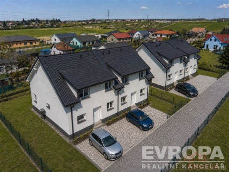 �adov� rodinn� domy s modern� fas�dou a parketov�mi p��jezdov�mi cestami, obklopen� zelen� a nach�zej�c� se v klidn� oblasti.