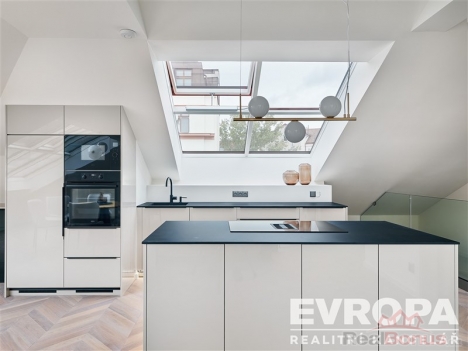 Modern� kuchy� s vestav�n�mi spot�ebi�i, parketovou podlahou a velk�mi st�e�n�mi okny, kter� zaji��uj� sv�tl� interi�r.