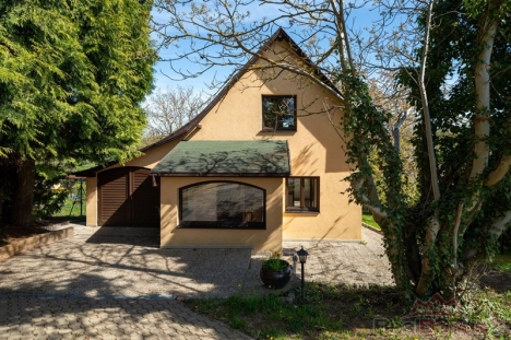 Rodinn� d�m s modern� fas�dou, obklopen� zelen�. Velk� okna poskytuj� dostatek sv�tla, p�kn� udr�ovan� pozemek, klidn� lokalita.