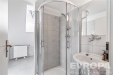 Modern� koupelna se sprchov�m koutem, sv�tl� dla�by a velk� okno zaji��uj�c� p�irozen� sv�tlo, v kombinaci s elegantn�m sanit�rn�m vybaven�m.