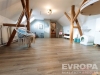 Prostorn� p�dn� m�stnost s d�ev�n�mi tr�my, lamin�tovou podlahou a st�e�n�mi okny, modern� a sv�tl� interi�r ide�ln� pro kreativn� vyu�it�.