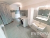 Prostorn� koupelna s dla�bou, modern�m osv�tlen�m a vestav�n�mi �lo�n�mi prostory, v�etn� pra�ky a z�v�sn�ho WC.