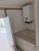 Mal� technick� m�stnost s modern�m kotlem, d�ev�n� oblo�en� a sv�tl� st�ny, ide�ln� pro �sporn� topen� v rekonstruovan�m dom�.