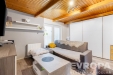 Sv�tl� ob�vac� pokoj s d�ev�n�mi stropy, modern� vestav�n� sk��n�, parketov� podlaha, �tuln� vybaven�, a elegantn� n�bytek.