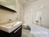 Modern� koupelna s keramickou dla�bou, sv�tl�mi obklady a praktick�m topn�m �eb��kem, nab�z� vanu a elegantn� umyvadlovou sk���ku.