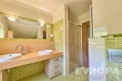 Modern� koupelna s d�ev�nou deskou, dv�ma umyvadly a sprchov�m koutem, zelen� obklady dod�vaj� sv�� vzhled, sv�tl� interi�r