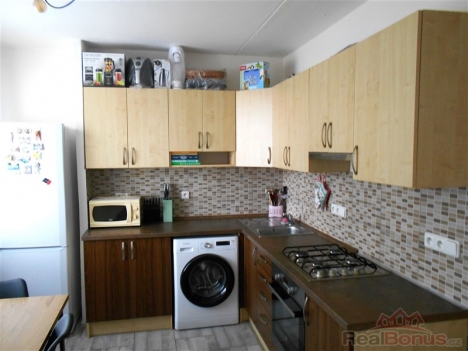 Modern� kuchy� s mozaikovou dla�bou, vestav�n� spot�ebi�e, d�ev�n� sk���ky, sv�tl� interi�r, prostor pro j�deln� st�l.