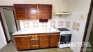 Kuchy� s d�ev�n�mi sk���kami, retro obklady a plynov�m spor�kem. Sv�tl� prostor s vinylovou podlahou, ide�ln� pro �pravy.