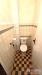 Mal� koupelna s dla�bou, sv�tl�mi kachli�kami a toaletou, jednoduch� prostorov� design v p�vodn�m stavu.
