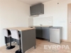 Modern� kuchy� s tmavou sk��n� a sv�tlou d�ev�nou pracovn� deskou, parketov� podlaha, barov� pult, minimalistick� design.