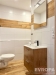 Modern� koupelna s d�ev�n�m obkladem a dla�bou, elegantn� umyvadlo s �lo�n�m prostorem, sv�tl� dla�dice a stylov� sv�tidlo