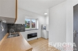 Kuchy� s d�ev�nou pracovn� deskou, dla�bou na st�n� a velk�m oknem, modern� �prava, sv�tl� m�stnost, p�ipraven� k vybaven�.