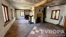 Rustik�ln� ob�vac� pokoj s kachlov�mi kamny, d�ev�n�mi tr�my a kombinovanou podlahou z dla�by a d�eva, vy�aduj�c� rekonstrukci.