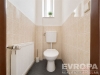 Samostatn� toaleta s modern� dla�bou, vysok�m stropem a �zk�m oknem, kter� zaji��uje p�irozen� osv�tlen�.