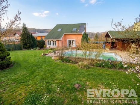 Zahrada s baz�nem, udr�ovan� tr�vn�k a alt�n. Rodinn� d�m m� modern� architekturu a velk� okna, nach�z� se v klidn� lokalit�.