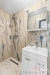 Modern� koupelna s mramorovou dla�bou, sprchov�m koutem a b�lou umyvadlovou sk���kou, v�e v elegantn�m a udr�ovan�m stavu