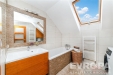 Koupelna s modern�m designem, rohovou vanou a dla�bou, velk� st�e�n� okno zaji��uje sv�tlost, d�ev�n� koupelnov� n�bytek p�id�v� eleganci.