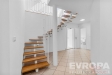 Modern� vstupn� hala s dla�bou, designov�m schodi�t�m s d�ev�n�mi stupni a b�l�mi z�bradl�m vytv��� sv�tl� a otev�en� prostor.
