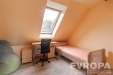 Podkrovn� pokoj s d�ev�nou podlahou, st�e�n� okno poskytuj�c� dostatek sv�tla, modern� n�bytek a sv�tl� st�ny vytv��ej� �tuln� prostor.