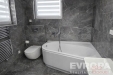 Modern� koupelna s mramorovou dla�bou, rohovou vanou a velk�m oknem. Elegantn� vzhled a kvalitn� materi�ly vytv��ej� luxusn� prostor.