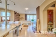 Modern� ob�vac� pokoj s d�ev�nou podlahou a velk�mi okny, sv�tl� interi�r s minimalistick�m n�bytkem a dekora�n�mi prvky.