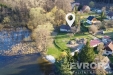 Leteck� pohled na malebnou venkovskou nemovitost v bl�zkosti les� a rybn�ka, s rozlehl�m pozemkem a klidnou okoln� p��rodou.