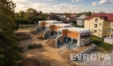 �adov� rodinn� domy ve v�stavb� s modern� architekturou, plochou st�echou a velk�mi okny, um�st�n� v klidn� reziden�n� �tvrti.