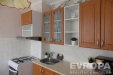 Kuchy� v klasick�m stylu s d�ev�n�mi sk���kami, sv�tlou pracovn� deskou a modern�mi spot�ebi�i, keramick� dla�ba na zdi