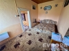 Jednoduch� lo�nice s vintage kobercem, sv�tl� st�ny, d�ev�n� strop a z�kladn� n�bytek.
