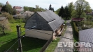 Tradi�n� venkovsk� d�m s �ikmou st�echou a zahradou, nach�z� se na klidn� vesnick� cest�, obklopen zelen� a starobyl�mi stromy.