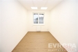 �zk� m�stnost s d�ev�nou podlahou, velk�m oknem a b�l�mi st�nami, p�sob� modern� a sv�tl�, ide�ln� pro kancel�� �i pracovnu.