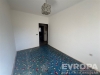 Pr�zdn� pokoj s b�l�mi st�nami, barevn�m kobercem a modern�m osv�tlen�m, vhodn� k rekonstrukci, sv�tl� interi�r