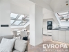 Modern� otev�en� prostor s parketovou podlahou, velk�mi st�e�n�mi okny a elegantn� kuchy�skou linkou, sv�tl� interi�r s j�deln�m koutem.
