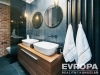 Modern� koupelna s d�ev�n�m umyvadlov�m pultem, keramick�mi umyvadly a velk�m zrcadlem, �ern� dla�dice, elegantn� osv�tlen�.
