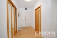 Chodba s parketovou podlahou a vestav�n�mi sk��n�mi, sv�tl� prostor s modern�mi d�ev�n�mi detaily a b�l�mi st�nami.