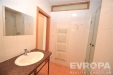 Koupelna s dla�bou a sprchov�m koutem, modern� zrcadlov� linka s umyvadlem, sv�tl� keramick� obklady a �lo�n� prostor za dve�mi.